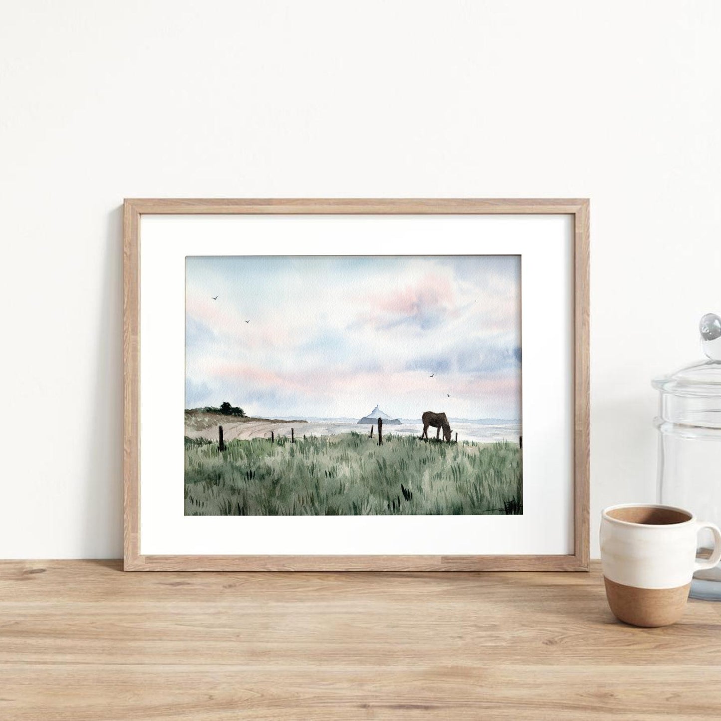 Reproduction encadrée d'une aquarelle d'un paysage de Saint-Jean-le6thomas avec une vue sur le Mont-Saint-Michel t le rocher de Tombelaine, réalisée par l'artiste normande Emma de Morel.