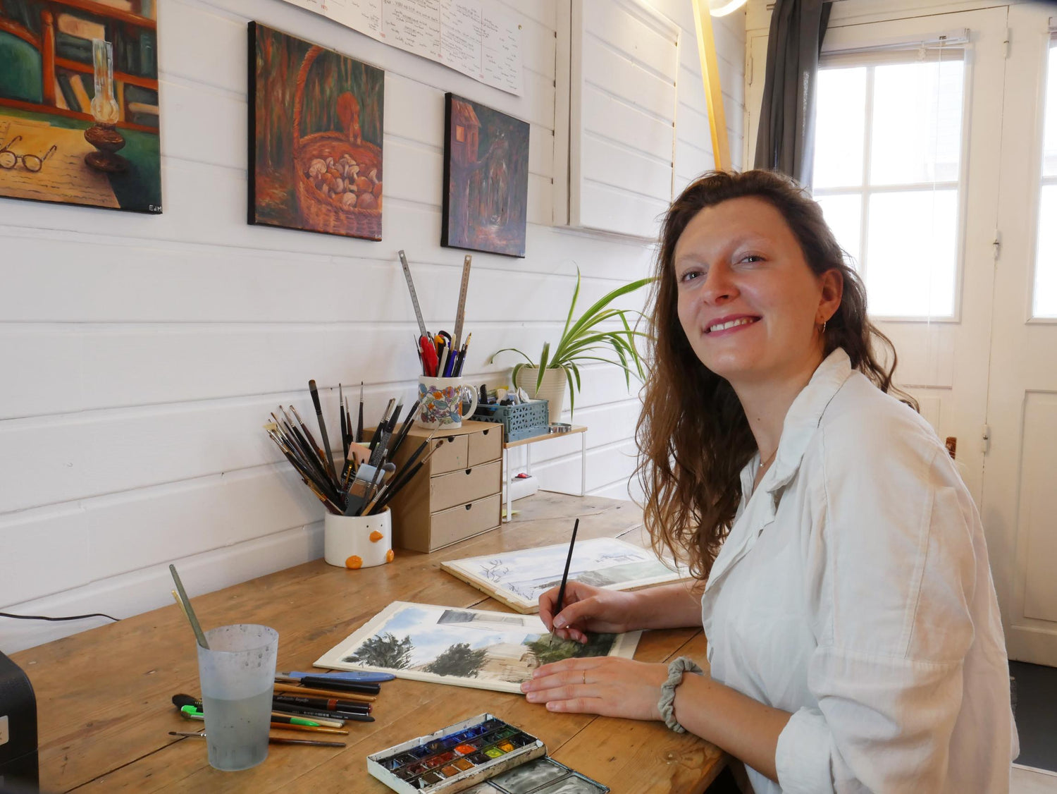 Artiste peintre normande, Emma de Morel peint des aquarelles de paysages dans son atelier d'art.