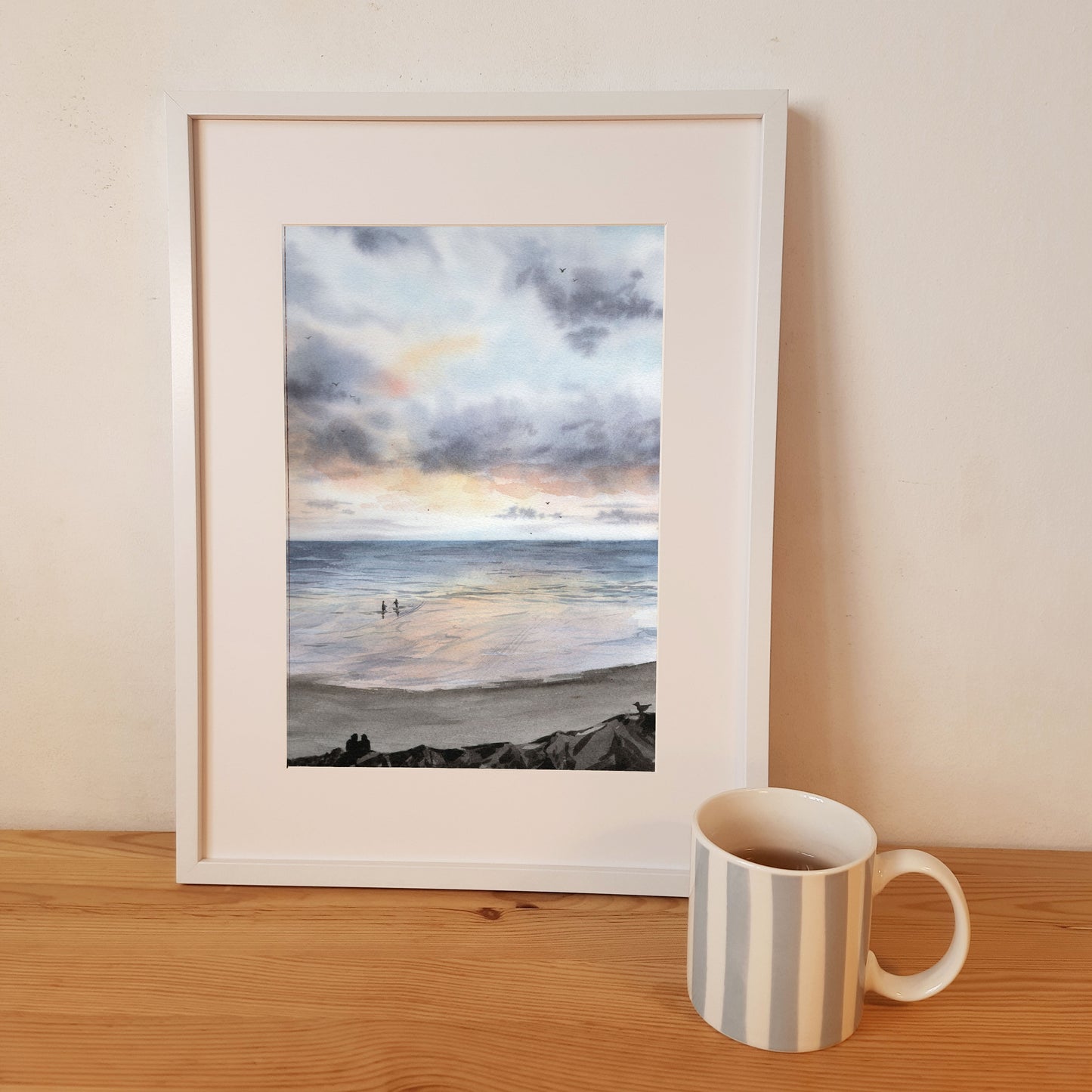 Reproduction A4 encadrée de mon aquarelle réaliste format portrait représentant la plage de Coutainville sous un ciel aux couleurs pastels.