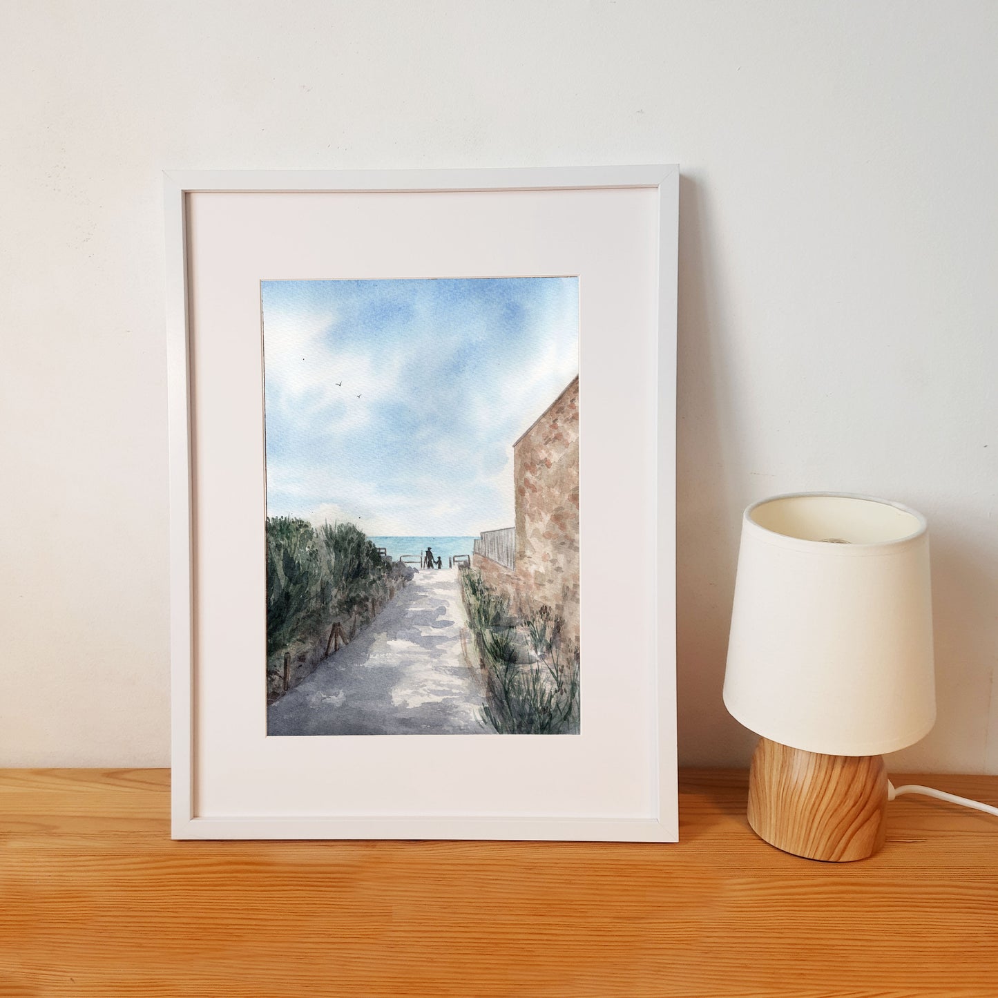 Reproduction A4 encadrée format portrait d'une aquarelle réaliste représentant une ruelle de Coutainville descendant vers la digue, un après-midi d'été.