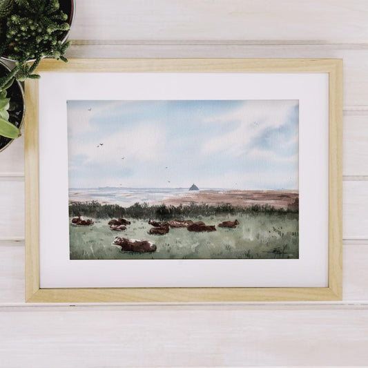 Reproduction encadrée d'une aquarelle de la Pointe du Grouin du Sud, avec des vaches en premier plan, réalisée par l'artiste normande Emma de Morel.