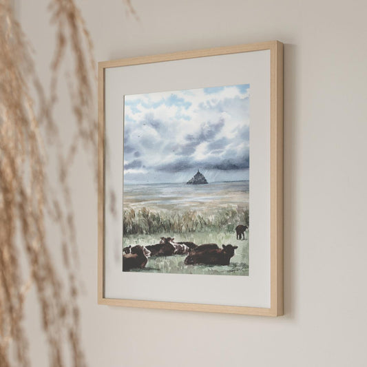 Reproduction encadrée d'une aquarelle de la Pointe du Grouin du Sud, avec des vaches en premier plan et une vue sur le Mont-Saint-Michel, réalisée par l'artiste normande Emma de Morel.
